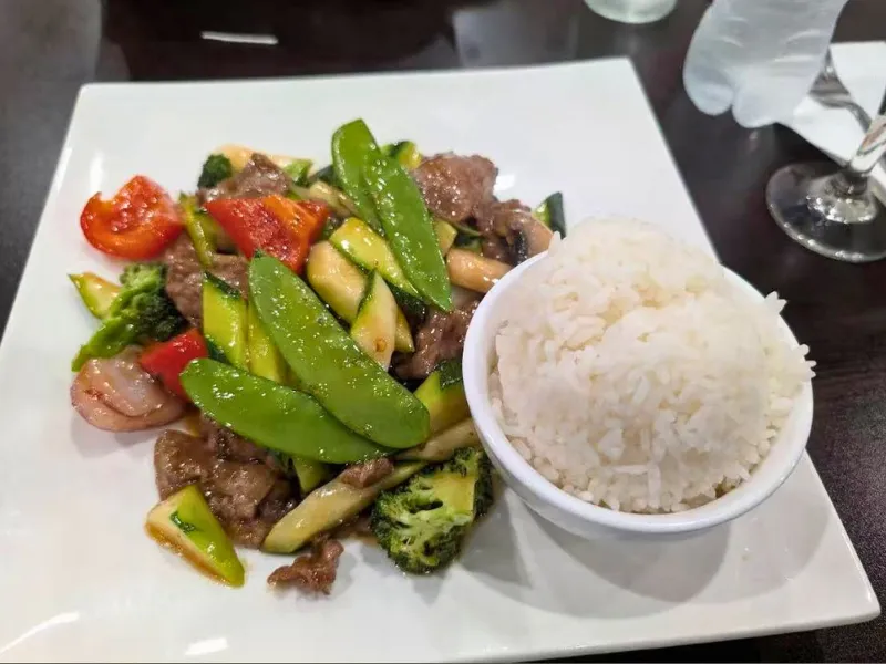 Stir-fried beef with snow peas and steamed rice at Mirai Sushi & Thai, a Sushi Restaurant in Lucie